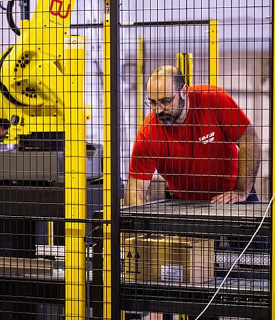 Técnico mecánico ajustando brazo robótico